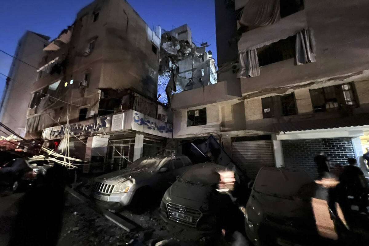 People inspect damaged cars in the southern suburbs of Beirut, Lebanon, Tuesday, July 30, 2024. ...