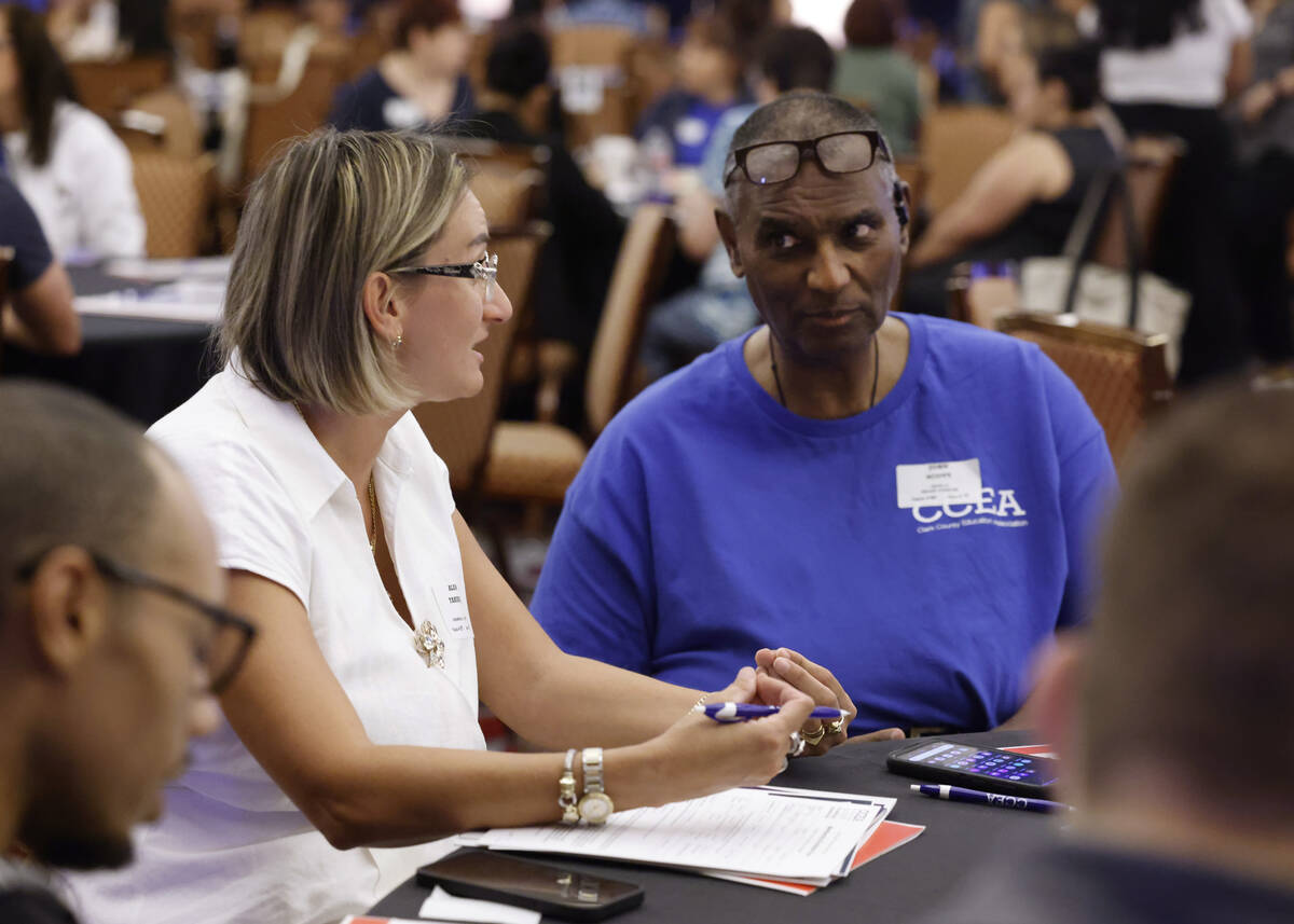 John Scott, right, Duane D Keller Middle School teacher, listens to Alda Tahiraj, a newly hired ...