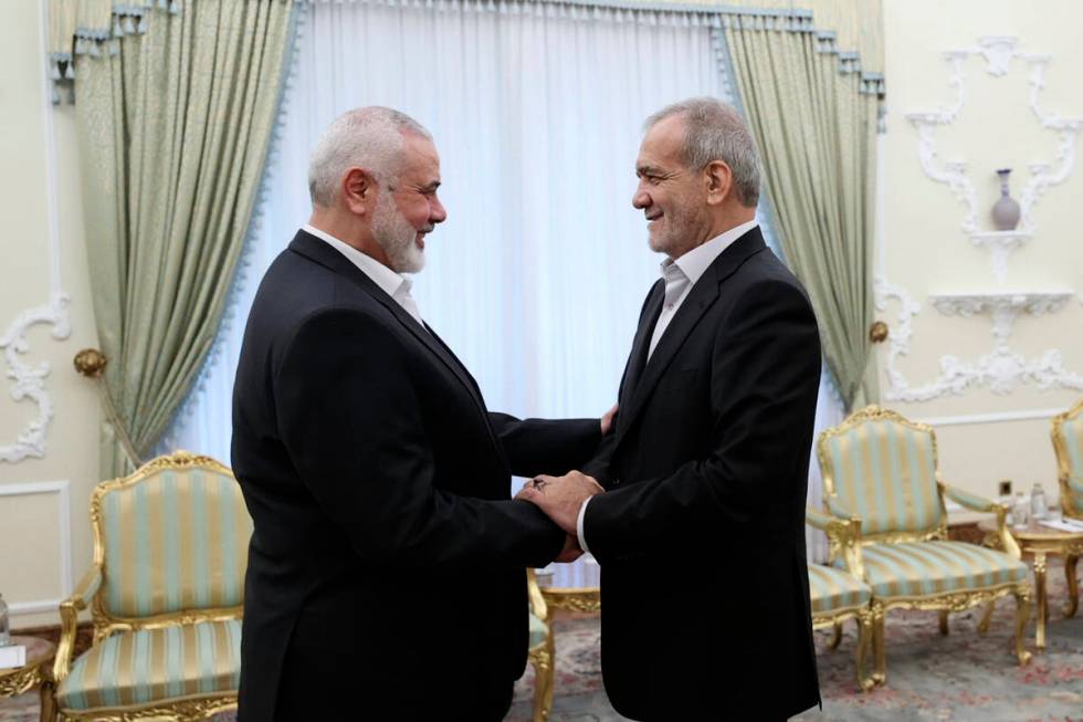 In this photo released by the Iranian Presidency Office, President Masoud Pezeshkian, right, sh ...