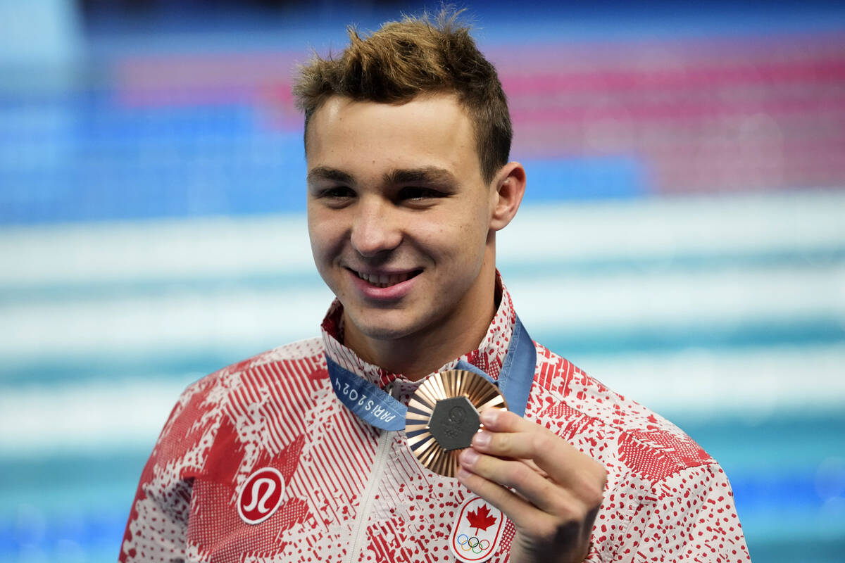 Ilya Kharun, of Canada, poses with his bronze medal following the men's 200-meter butterfly fin ...