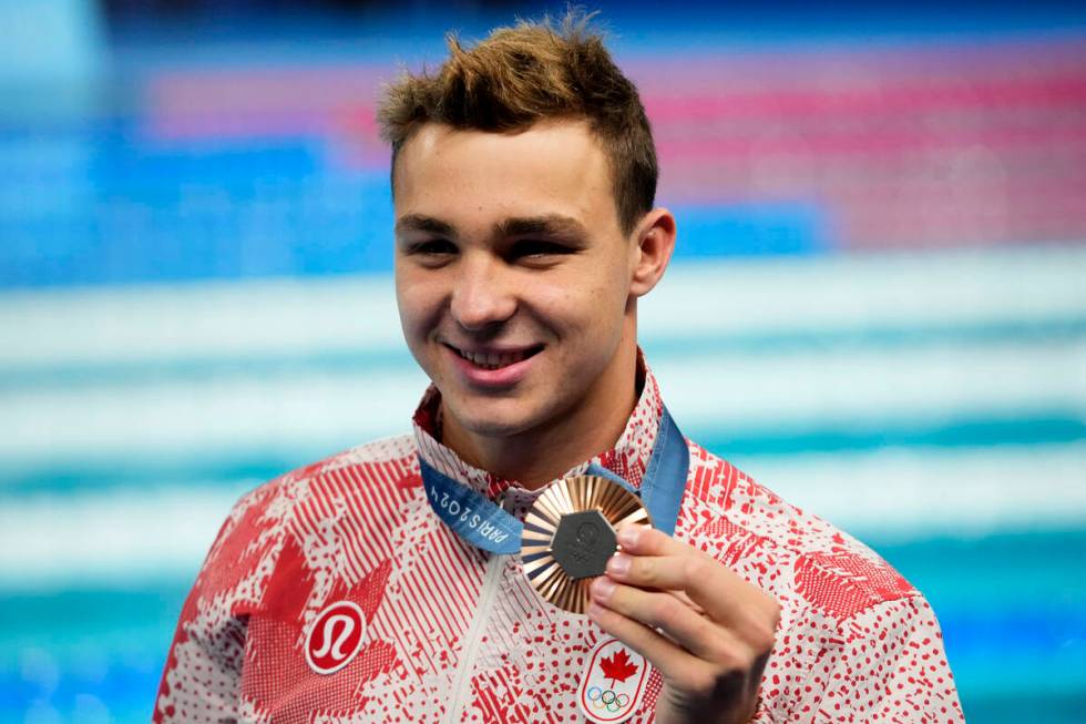 Ilya Kharun, of Canada, poses with his bronze medal following the men's 200-meter butterfly fin ...