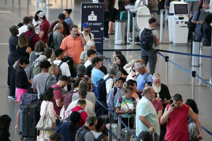 Passengers wait in line for assistance at the Delta Terminal, July 19, 2024, at Logan Internati ...