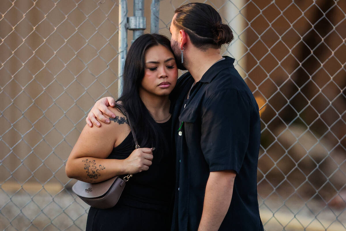 Mourners embrace during a vigil for Kameron Moore and Vincent Herrera at the Riverbend Village ...