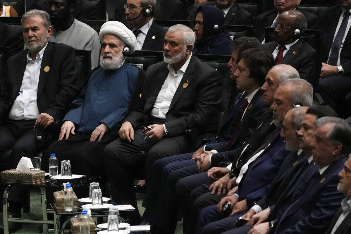 Hamas chief Ismail Haniyeh, center, sits next to the deputy leader of the Lebanese militant gro ...