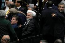 Hamas chief Ismail Haniyeh, center, sits prior to the start of the swearing-in ceremony of newl ...