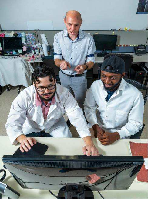 (Clockwise from top) UNLV professor James Hyman looks at data with Ph.D. students Talha Soluoku ...