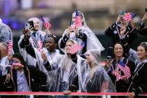 Members of the United States Team travels along the Seine River in Paris, France, during the op ...