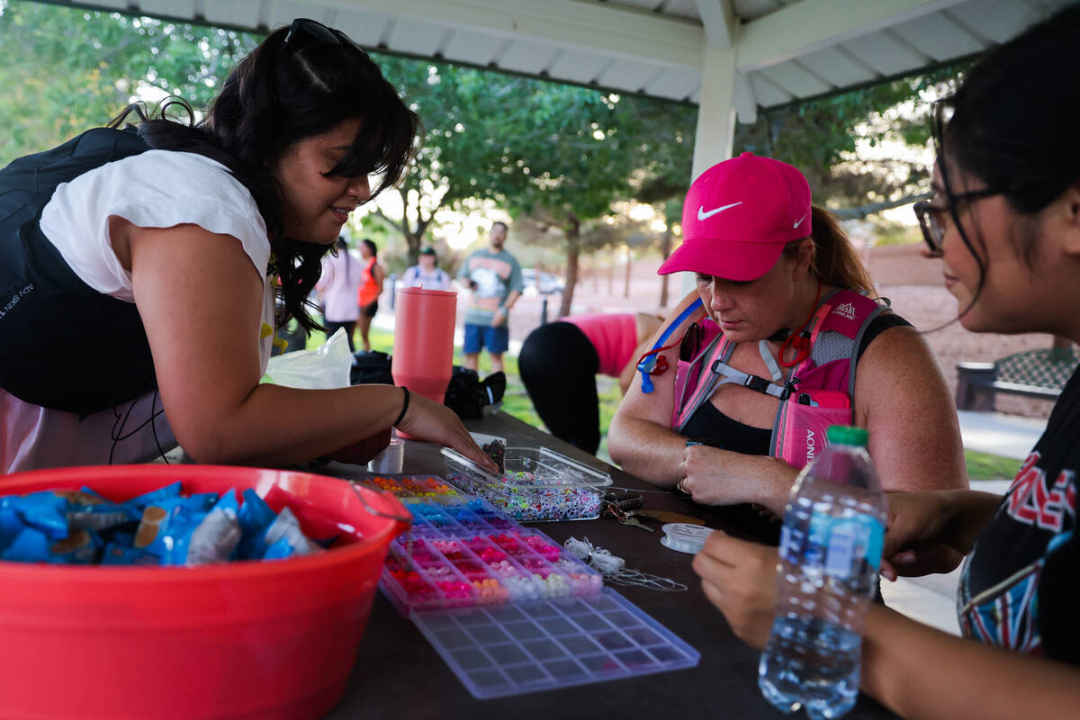 Emma Edwards, middle, makes a friendship bracelet during a Las Vegas Girls Run Club meeting at ...