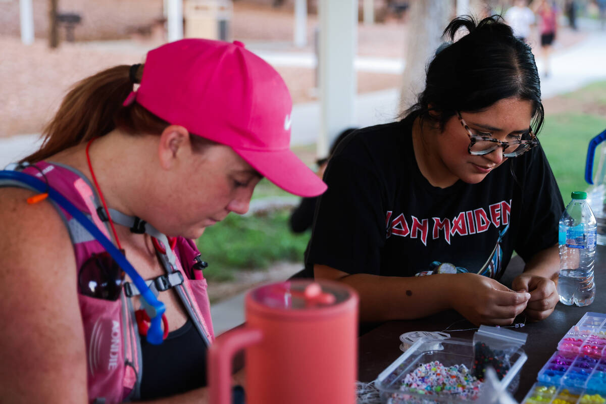 Emma Edwards, left, makes friendship bracelets with Analiza Beaz during a Las Vegas Girls Run C ...