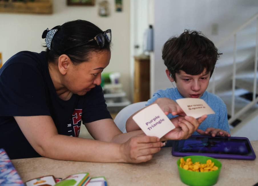 Caroline Ver, a registered behavior technician, works with Jakob Velez, 8, on a colors and shap ...