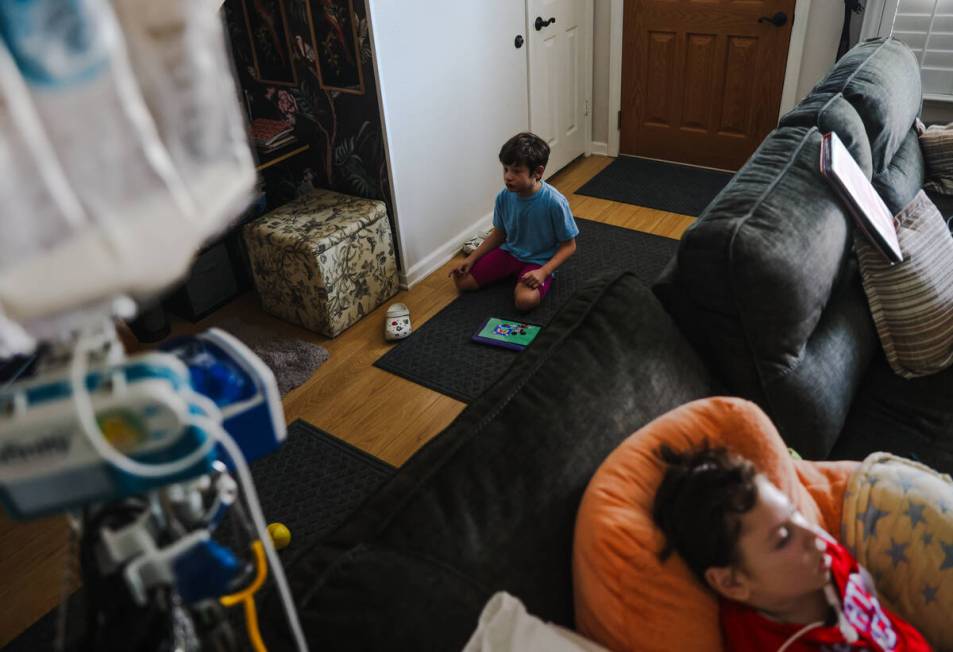 Jakob Velez, 8, sits on the floor with his iPad near his brother, Danyel Velez, 5, at their hom ...