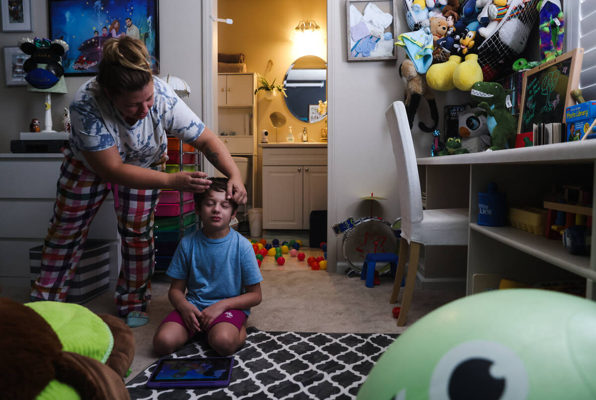 Heidi Tunea fixes the hair of her son Jakob Velez, 8, at their home in Las Vegas on July 24, 20 ...