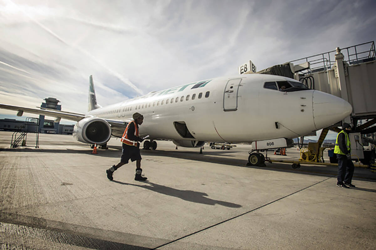 A ground crew at Harry Reid International Airport prepares a WestJet for takeoff on Tuesday, De ...