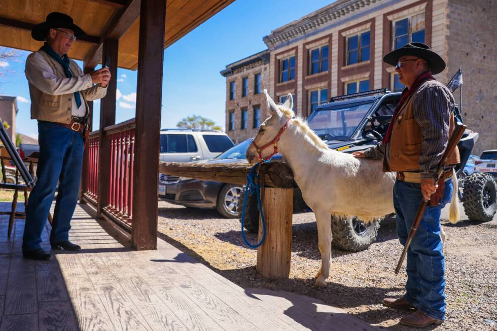 Goldfield Days parade participants take a photograph with a burro during Goldfield Days on Satu ...