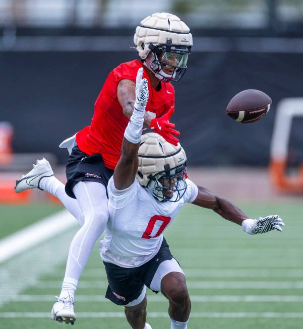 UNLV defensive back Tony Grimes (0) works to break up a pass to wide receiver Jaden Bradley (0) ...