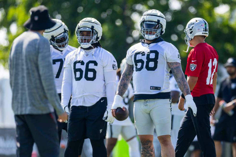 Raiders center Andre James (68) and guard Dylan Parham (66) listen to a coach during the second ...