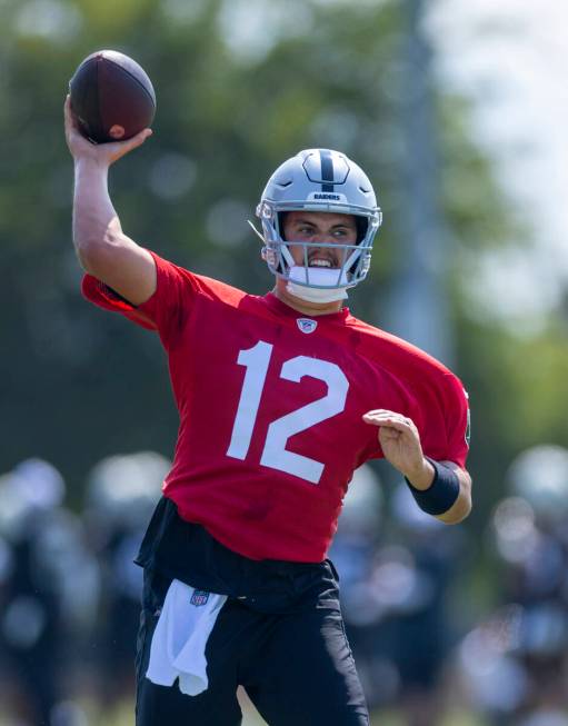 Raiders quarterback Aidan O'Connell (12) eyes a receiver during the first day of training camp ...