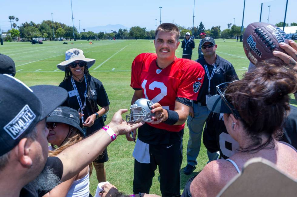 Raiders quarterback Aidan O'Connell (12) signs autographs for fans following the third day of t ...