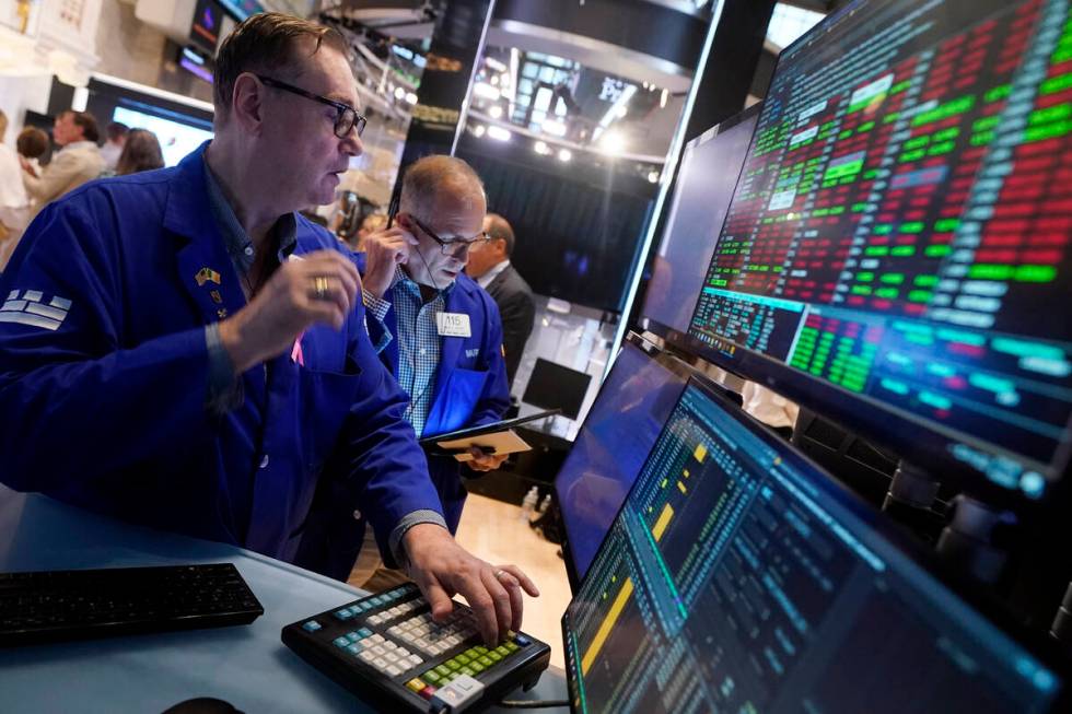 Specialist Patrick King, left, works at his post on the floor of the New York Stock Exchange, T ...