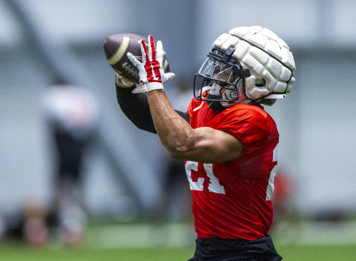 UNLV wide receiver Jacob De Jesus (21) secures a pass during football practice at the Intermoun ...