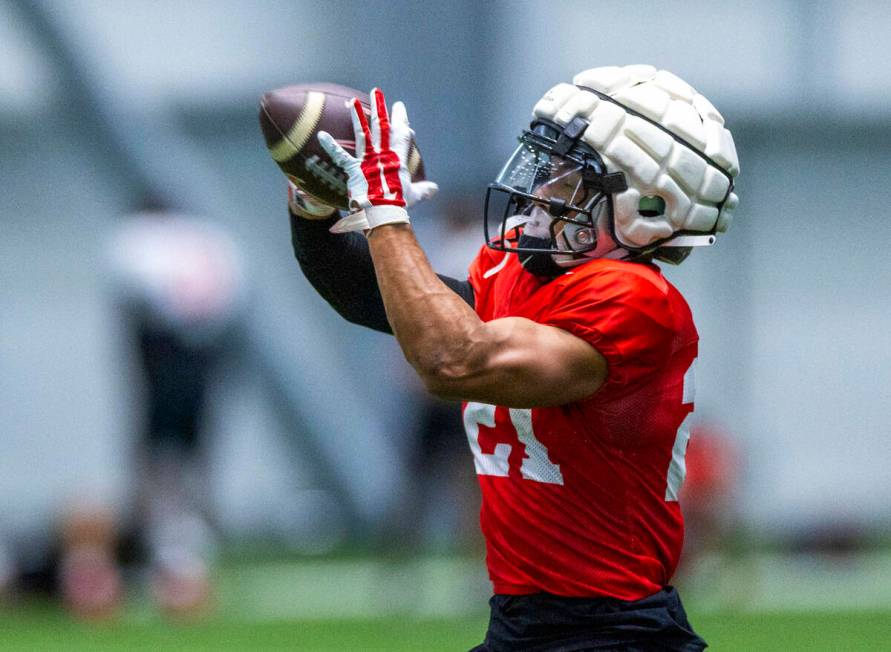 UNLV wide receiver Jacob De Jesus (21) secures a pass during football practice at the Intermoun ...