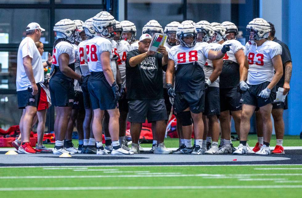 UNLV defensive line coach Ricky Logo works with his players during football practice at the Int ...