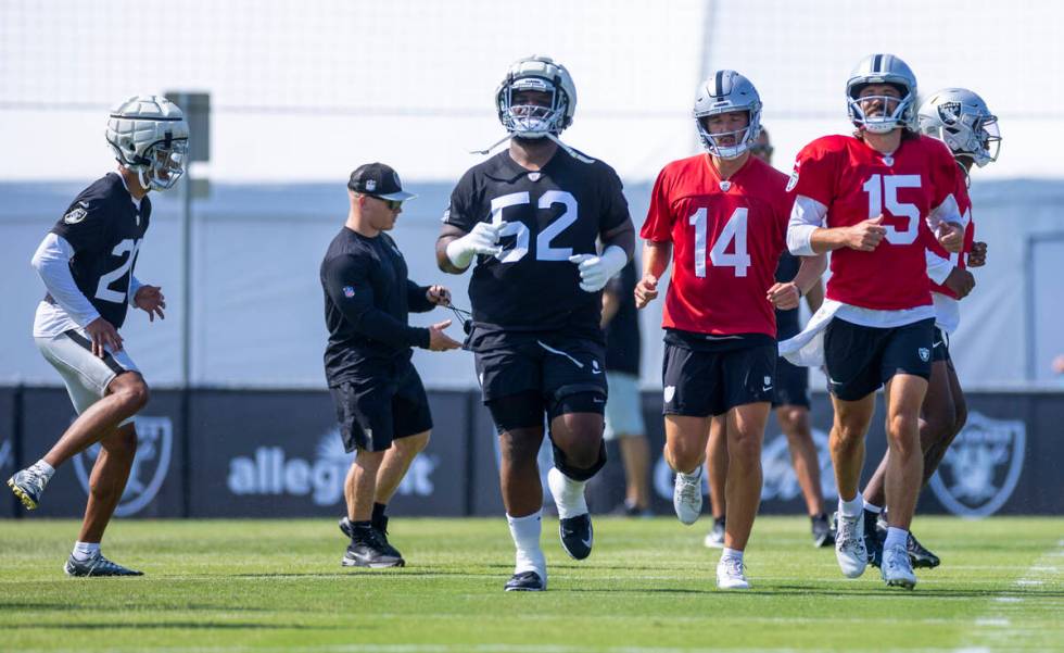 Raiders defensive tackle Marquan McCall (52) runs a drill with quarterback's Carter Bradley (14 ...