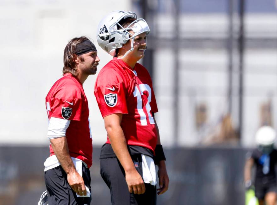 Raiders quarterbacks Aidan O'Connell (12) Gardner Minshew II (15) listen to a coach instruction ...