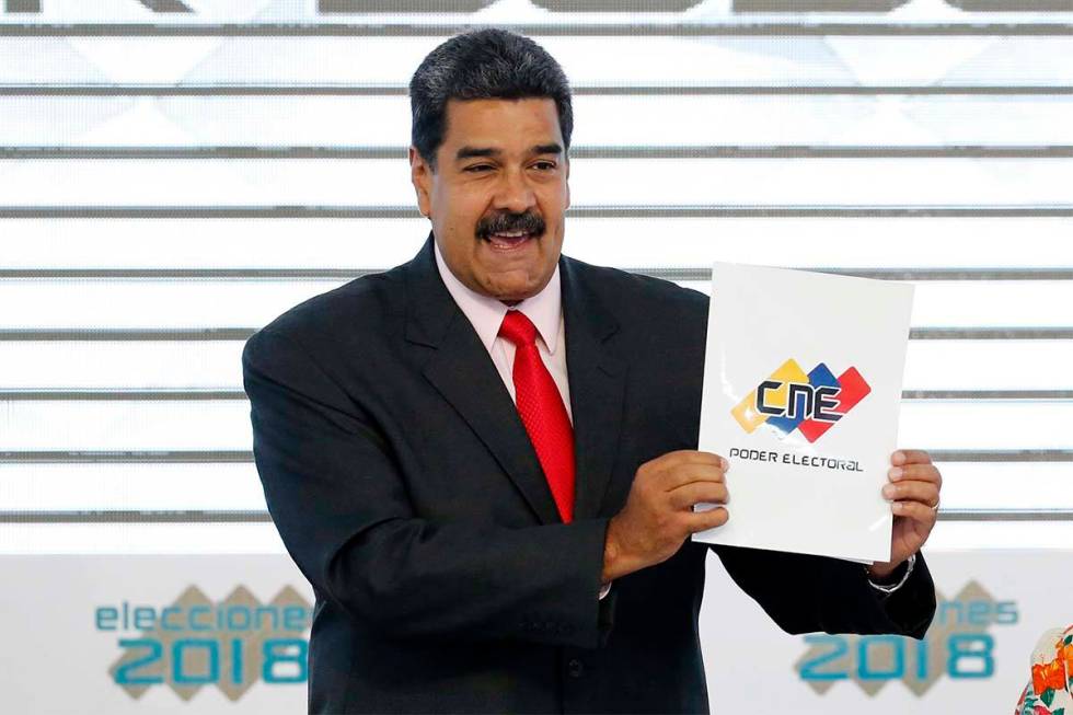 In this May 22, 2018, file photo, Venezuela's President Nicolas Maduro holds up the National El ...