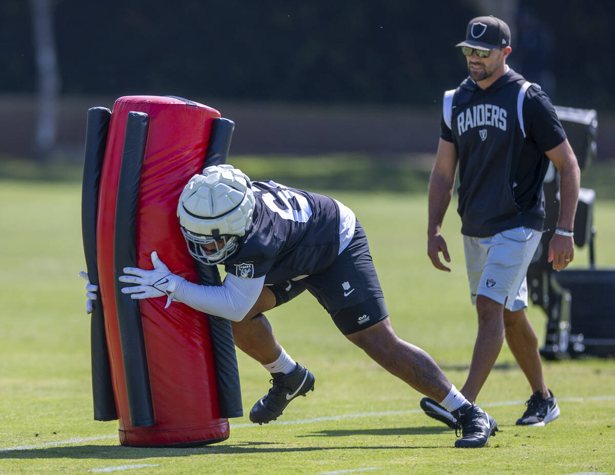 Raiders center Will Putnam (67) tackles a dummy on a drill during the second day of Raiders tra ...