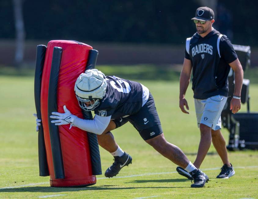 Raiders center Will Putnam (67) tackles a dummy on a drill during the second day of Raiders tra ...