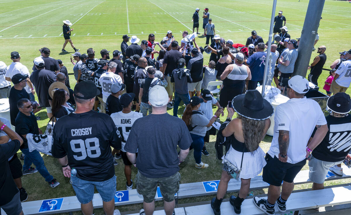 Raiders players take time to sign autographs for fans following the third day of training camp ...