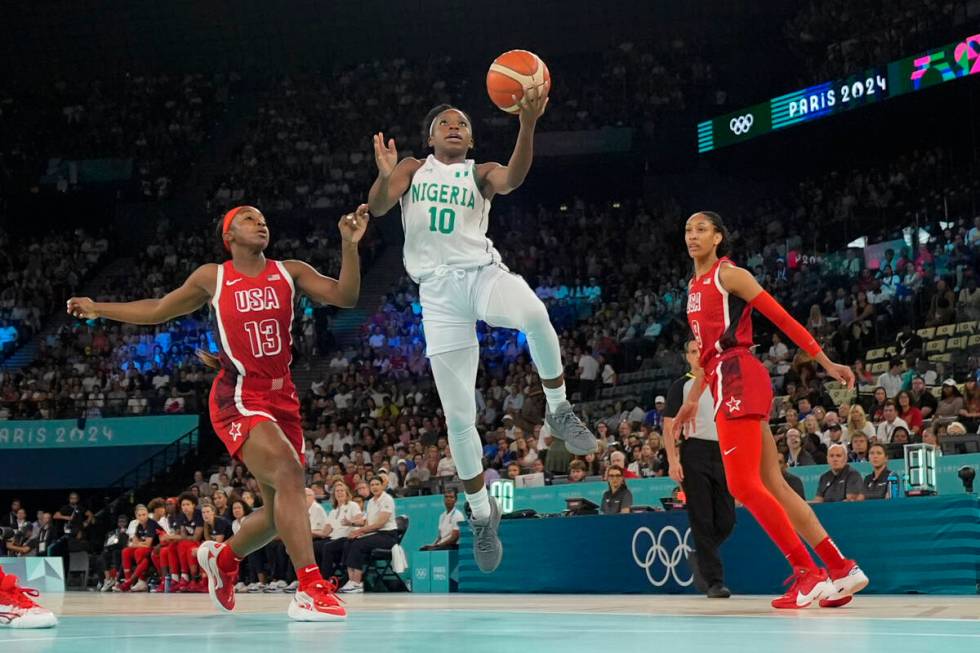 Promise Amukamara (10), of Nigeria, shoots between United States' Jackie Young (13) and A'ja Wi ...