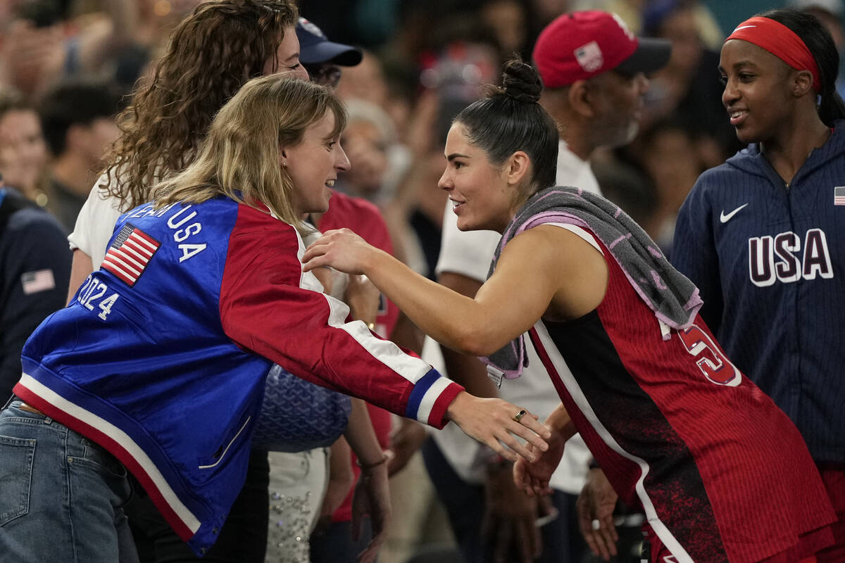 Swimmer Katie Ledecky shakes hands with United States' Kelsey Plum (5) following a women's quar ...