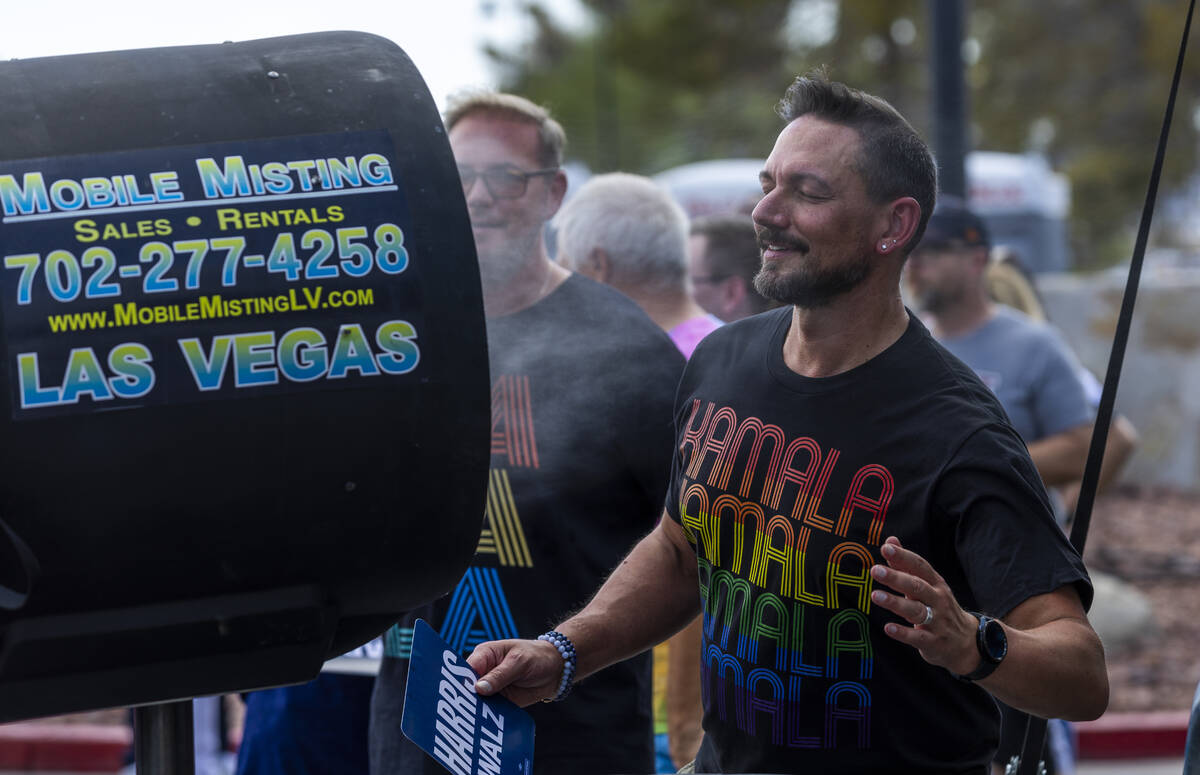 Attendees sneak a quick misting while waiting in the sun to be screened for entry as Vice Presi ...