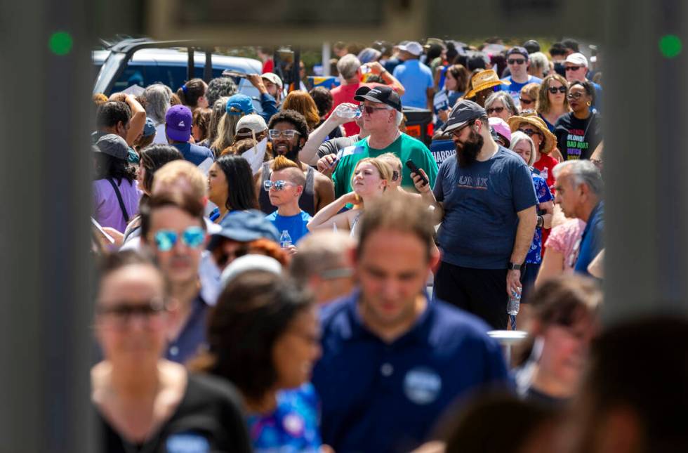 Attendees line up in the sun to be screened for entry as Vice President Kamala Harris and her r ...