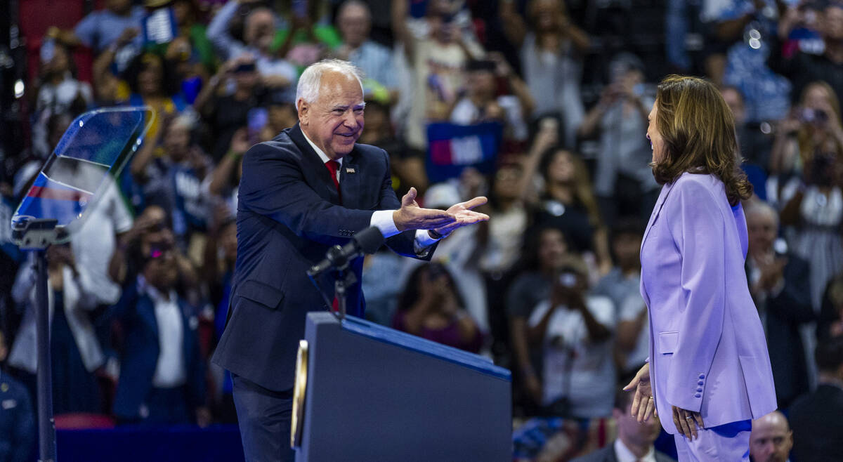 Minnesota Gov. Tim Walz greets Vice President Kamala Harris as she arrives on stage during a ca ...