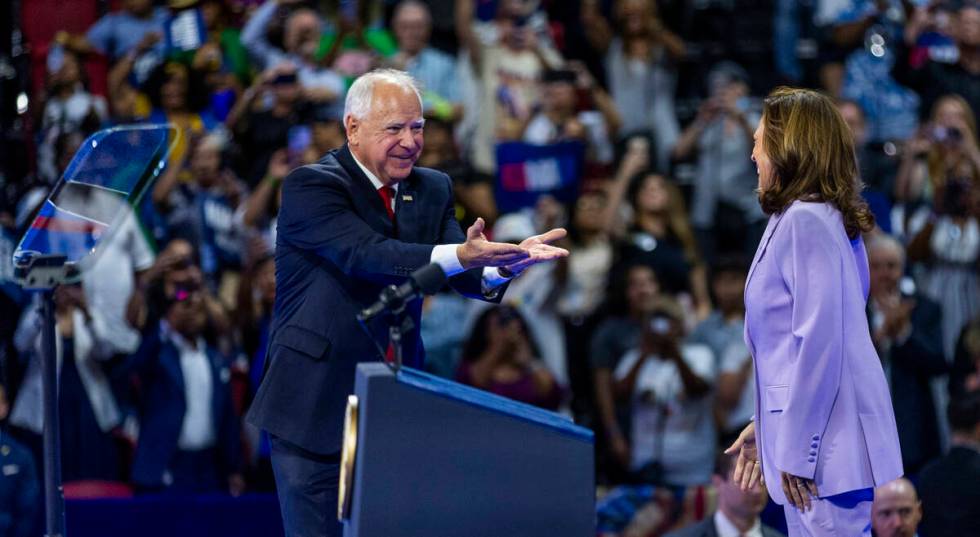 Minnesota Gov. Tim Walz greets Vice President Kamala Harris as she arrives on stage during a ca ...