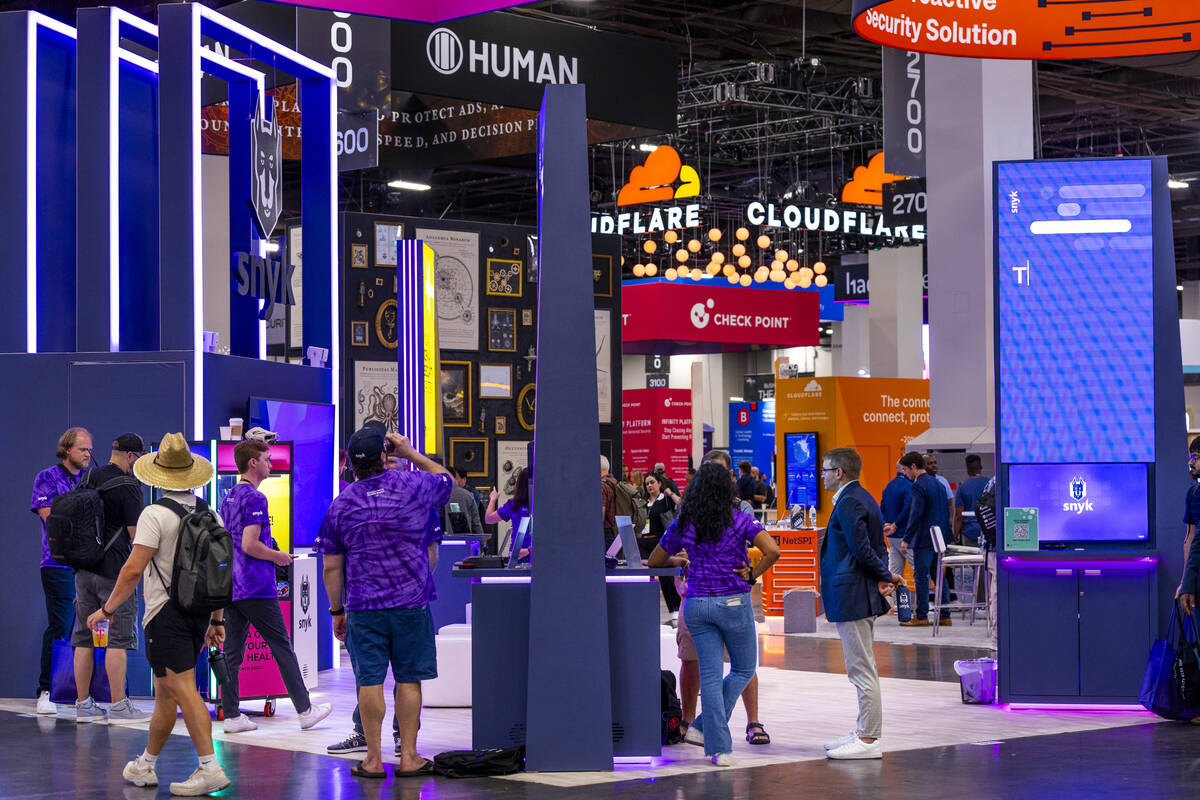 Attendees wander about the various displays during the Black Hat convention at the Mandalay Bay ...