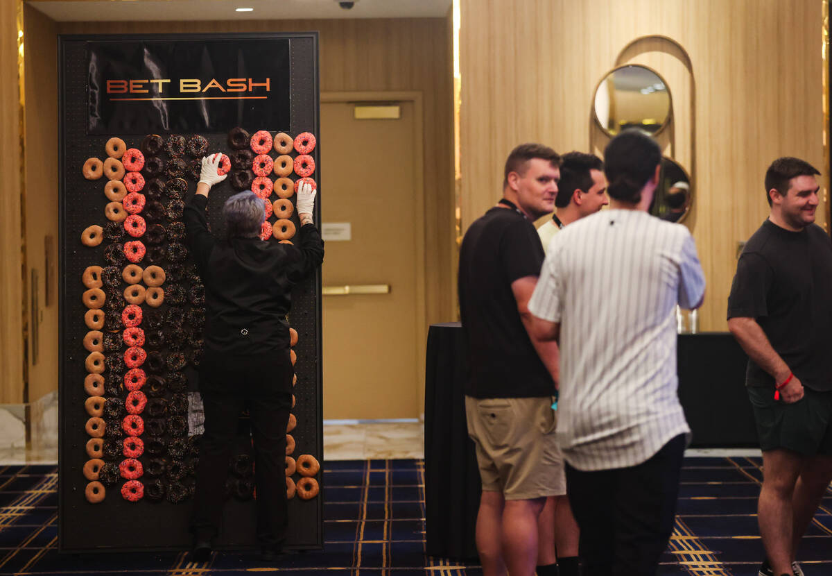 A worker adjusts donuts on a board at Bet Bash, a sports gambling convention, at Circa hotel-ca ...