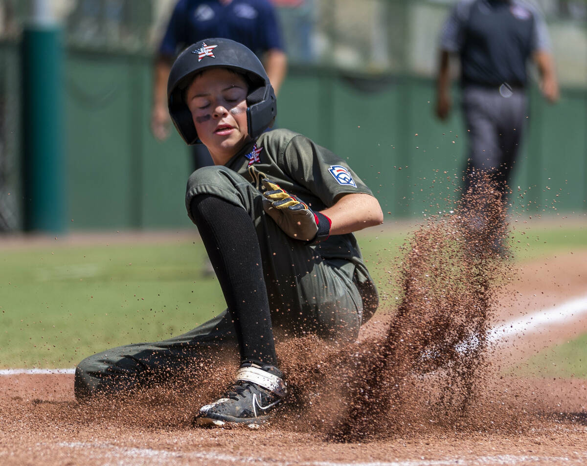 Nevada outfielder Dominic Laino (17) slides safely into home against Utah during the first inni ...