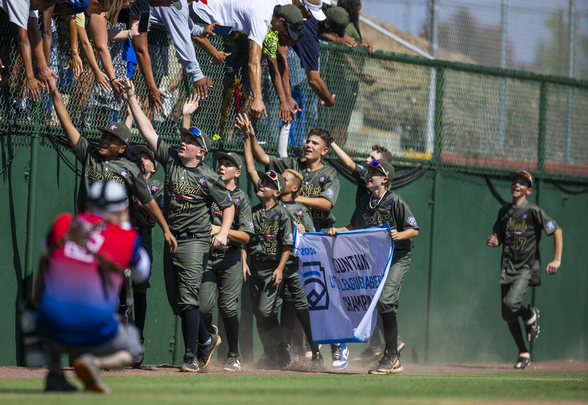 Nevada players celebrate on the field with their fans and winning banner after defeating Utah 2 ...