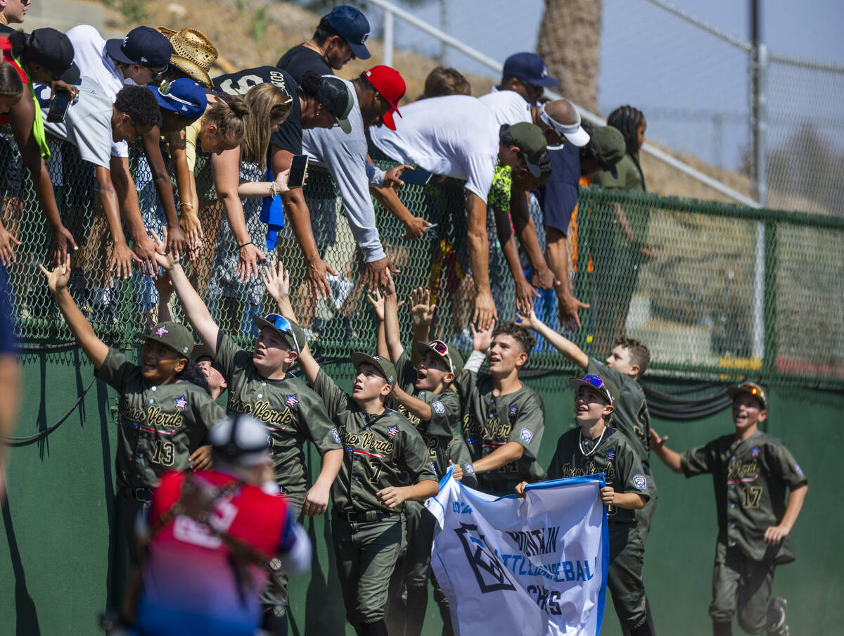 Nevada players celebrate on the field with their fans and winning banner after defeating Utah 2 ...