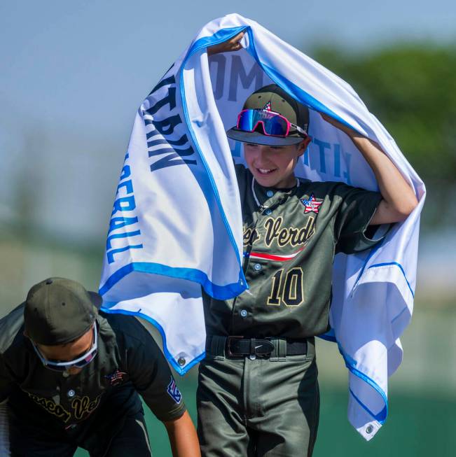 Nevada extra hitter Jimmy Foss (10) wears the winning banner beside infielder Russell McGee (2) ...