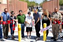 Rayan Kim, 12, assists Clark County Commissioner Justin Jones, center, in a ribbon cutting cere ...