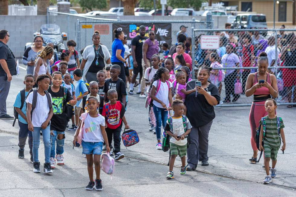 Students and parents enter for a red carpet welcome for their first day of school at Matt Kelly ...