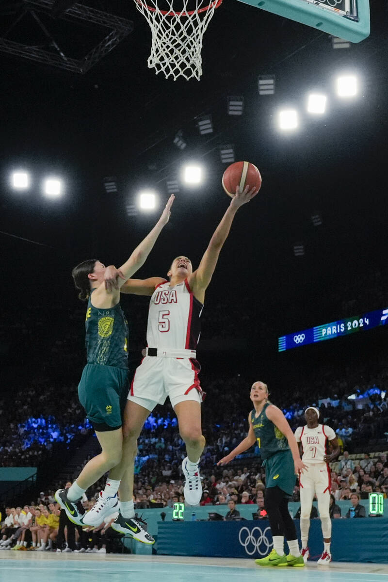 United States' Kelsey Plum (5) goes up under pressure form Jade Melbourne (2), of Australia, du ...