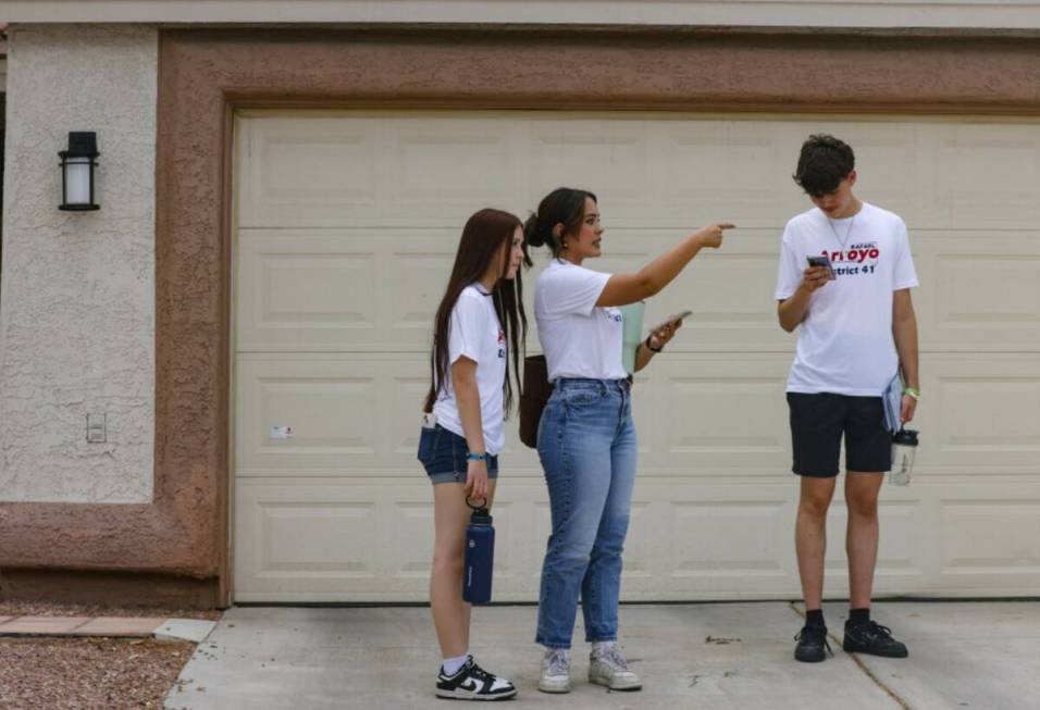 Volunteers Zaira Babcock, 14, her sister Zoe Babcock, 17, and Max Maroe, 18, canvass a neighbo ...