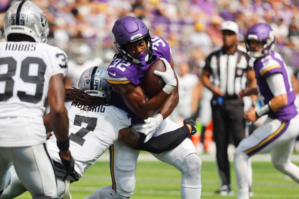 Minnesota Vikings running back Ty Chandler (32) is hit by Las Vegas Raiders safety Tre'von Moeh ...