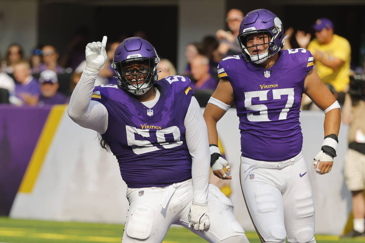 Minnesota Vikings defensive tackle Levi Drake Rodriguez (50) and linebacker Owen Porter (57) ce ...